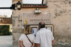 Clients lisant la carte devant le restaurant Le Lancelot à Chilleurs-aux-Bois